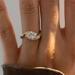 Load image into Gallery viewer, Gold ring with a diamond on a person's finger against a neutral background